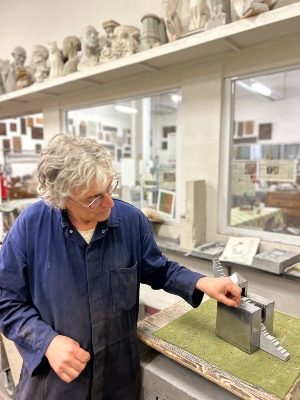 Luc Lingier in het atelier van Crescendo CVO toont een werkstuk uit natuursteen